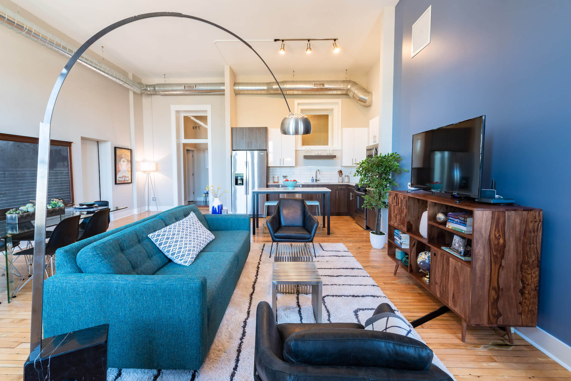 Living space with high ceiling open to kitchen and dining area.