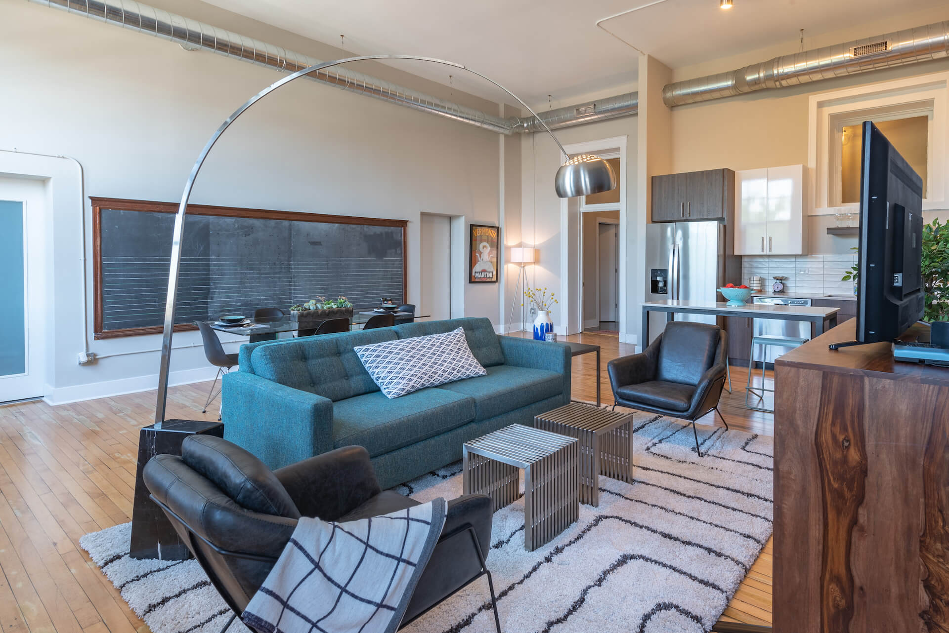 Living space with high ceiling open to kitchen and dining area.