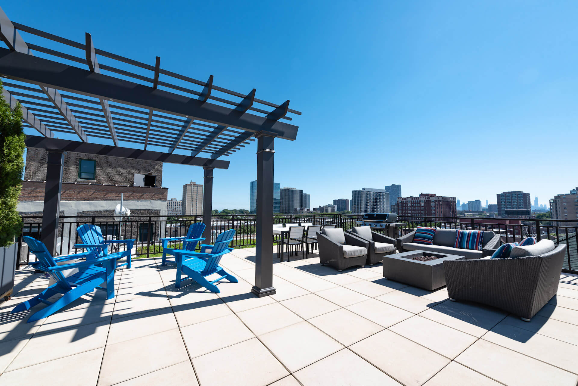 Rooftop patio with pergola and adirondack chairs, firepit with cushioned seating, and grill area.