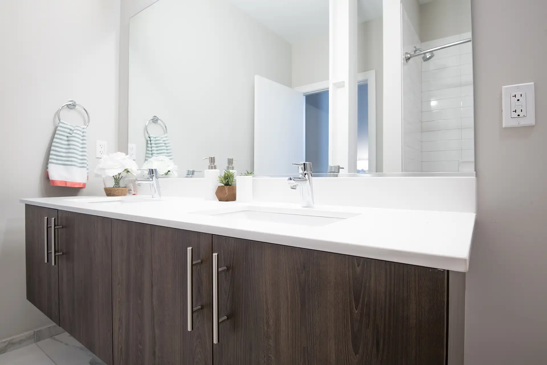 Double vanity with large mirror, custom cabinetry, and modern chrome fixtures.